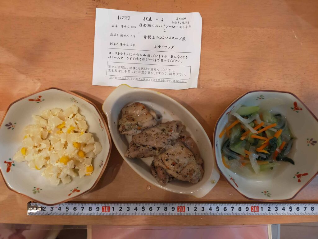 わんまいる健幸ディナーの1食分、主菜は、日南鶏のスパイシーローストチキン、副菜はチンゲン菜のコンソメスープ煮、ポテトサラダ