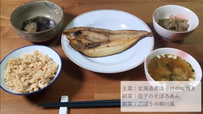 わんまいるの焼き魚セット。主菜は北海道産ほっけの塩焼き、副菜には茄子のそぼろあん、ごぼうの柳川風が揃った定食風の食事。玄米ご飯と味噌汁はレビュー者が用意したもの。