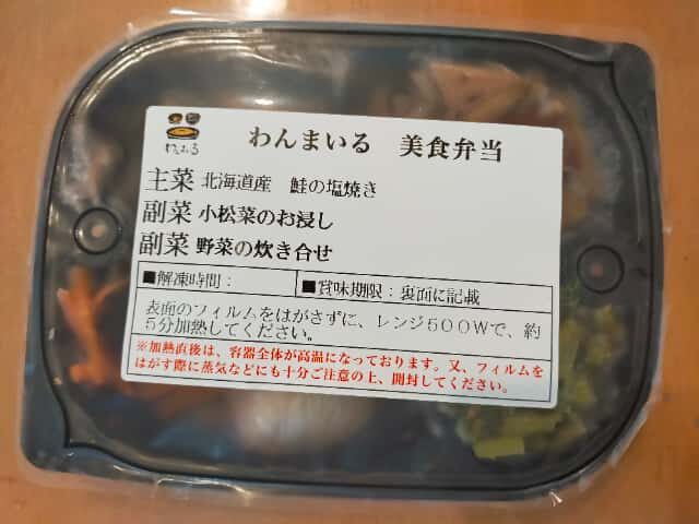 わんまいる美食弁当「北海道産 鮭の塩焼き」。主菜に北海道産の鮭の塩焼き、副菜に小松菜のお浸しと野菜の炊き合わせが入っている。電子レンジ500Wで約5分加熱して食べる仕様。